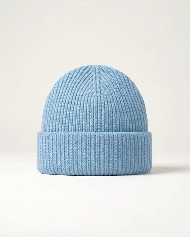 Product shot of a light blue merino wool beanie on a plain background