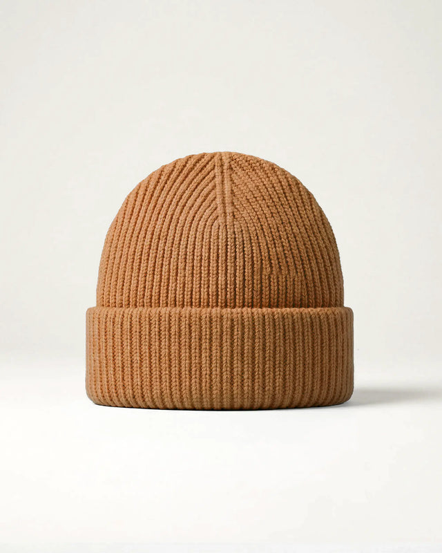 Brown knit beanie on a light beige background