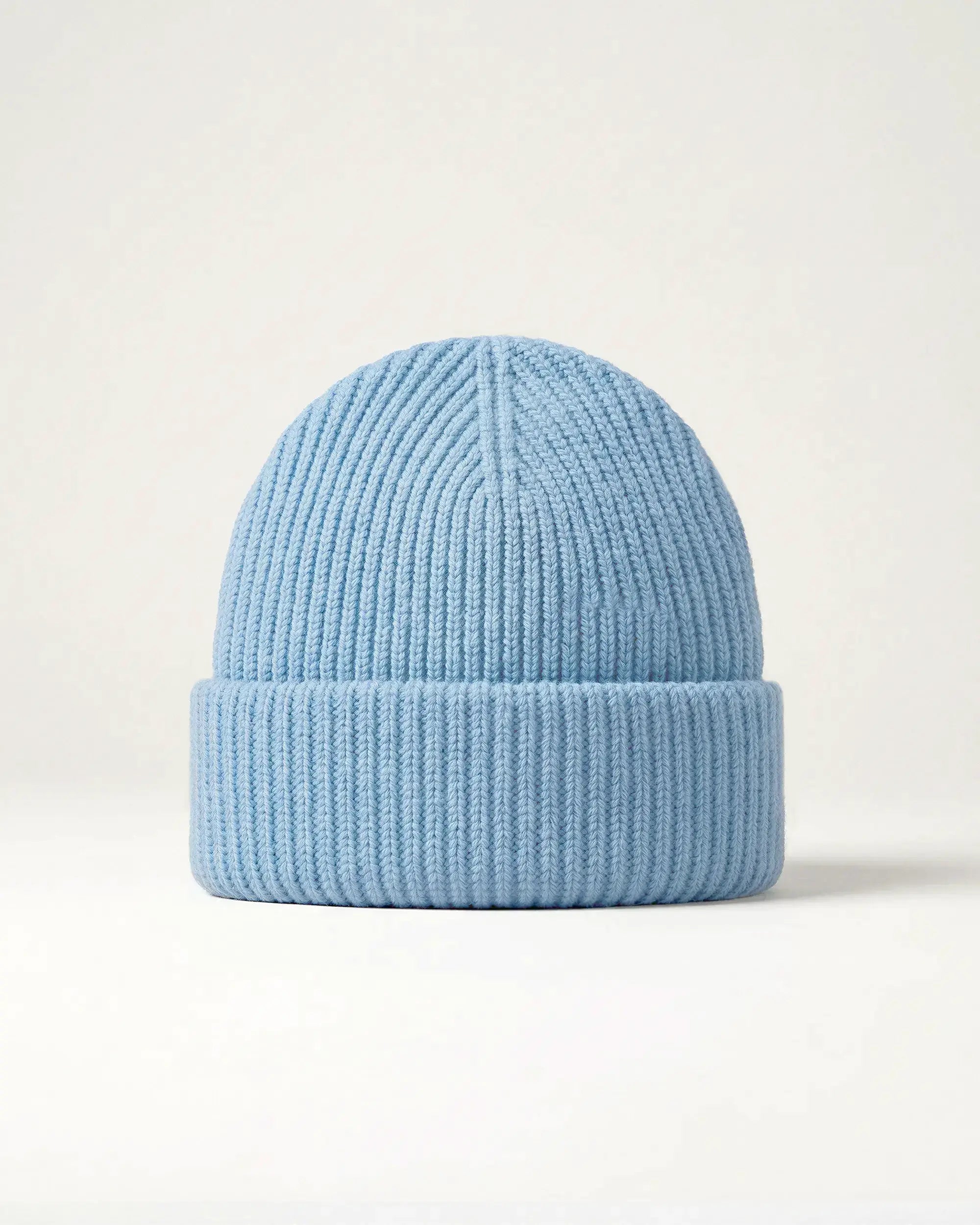 Product shot of a light blue merino wool beanie on a plain background
