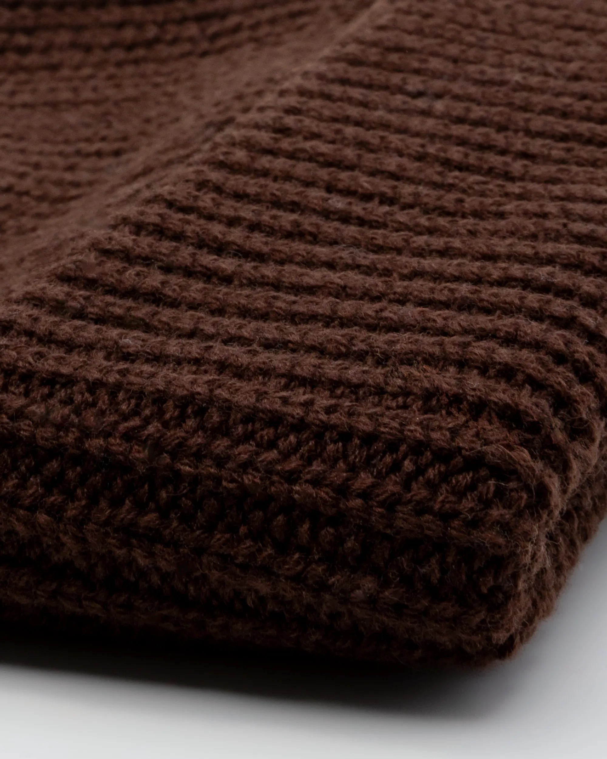 Close-up of a brown textured beanie on a white background