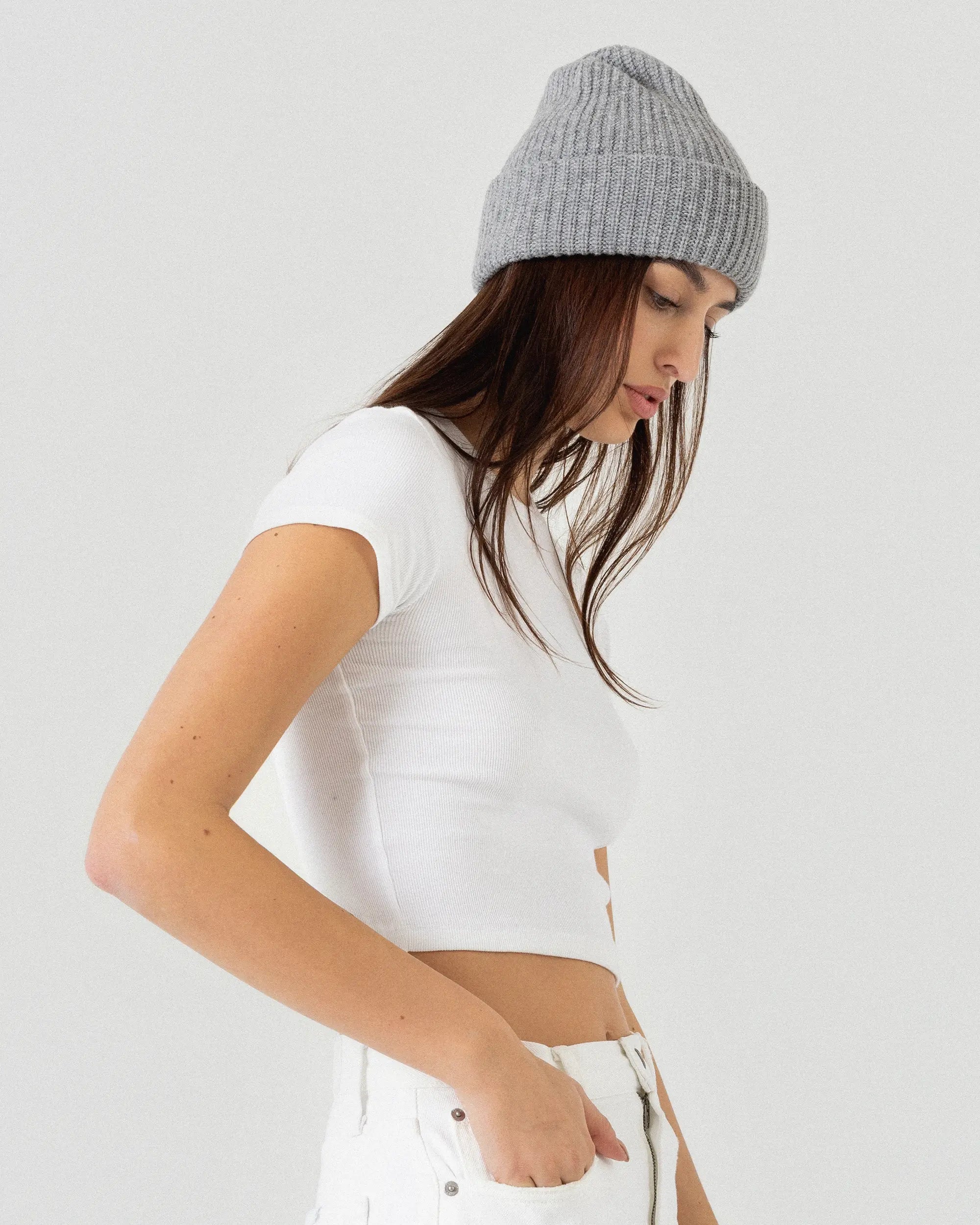 Woman wearing grey merino wool beanie on a white background