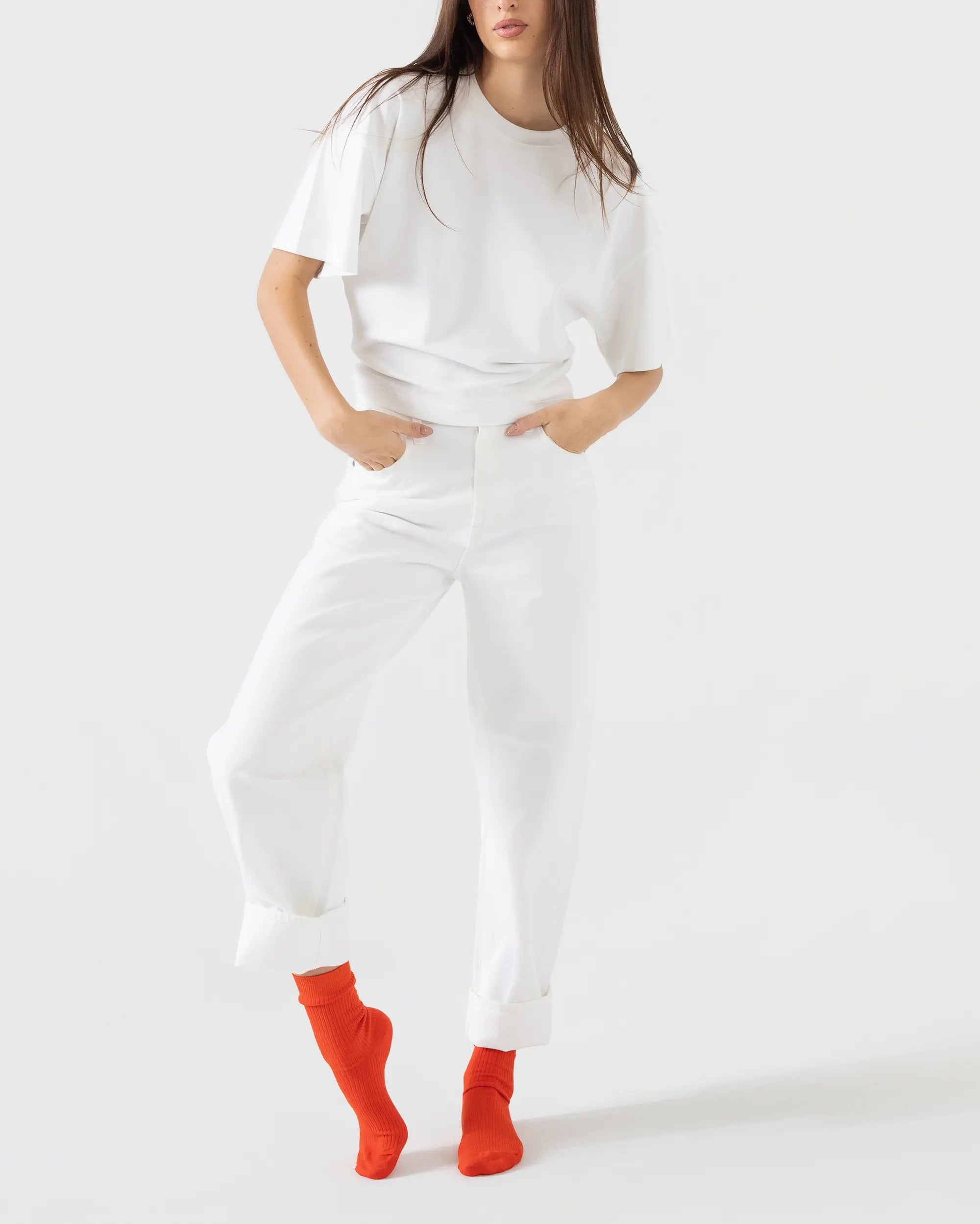 Person wearing a white outfit with red socks on a white background