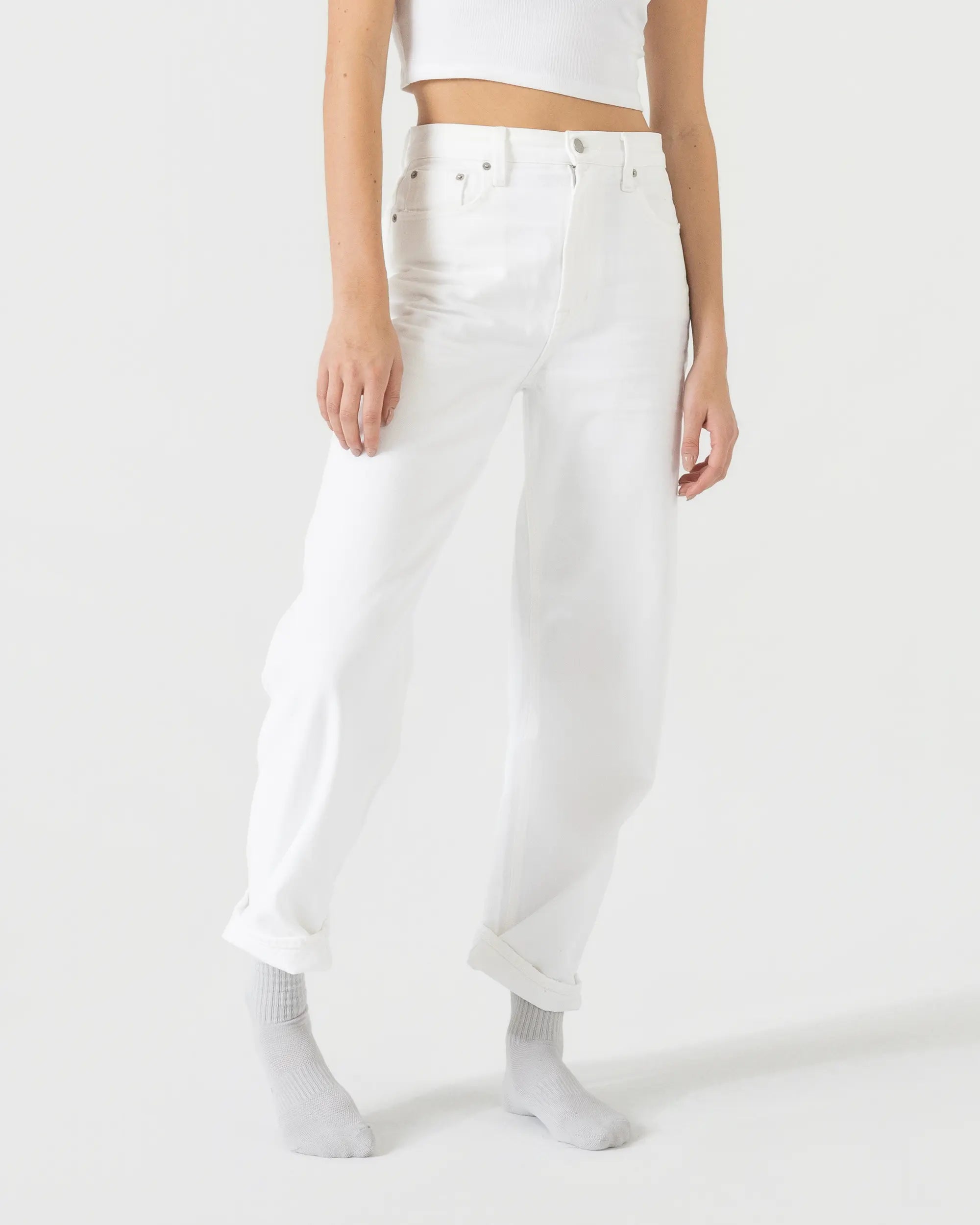 Person wearing light grey sport socks with a white outfit on a plain background