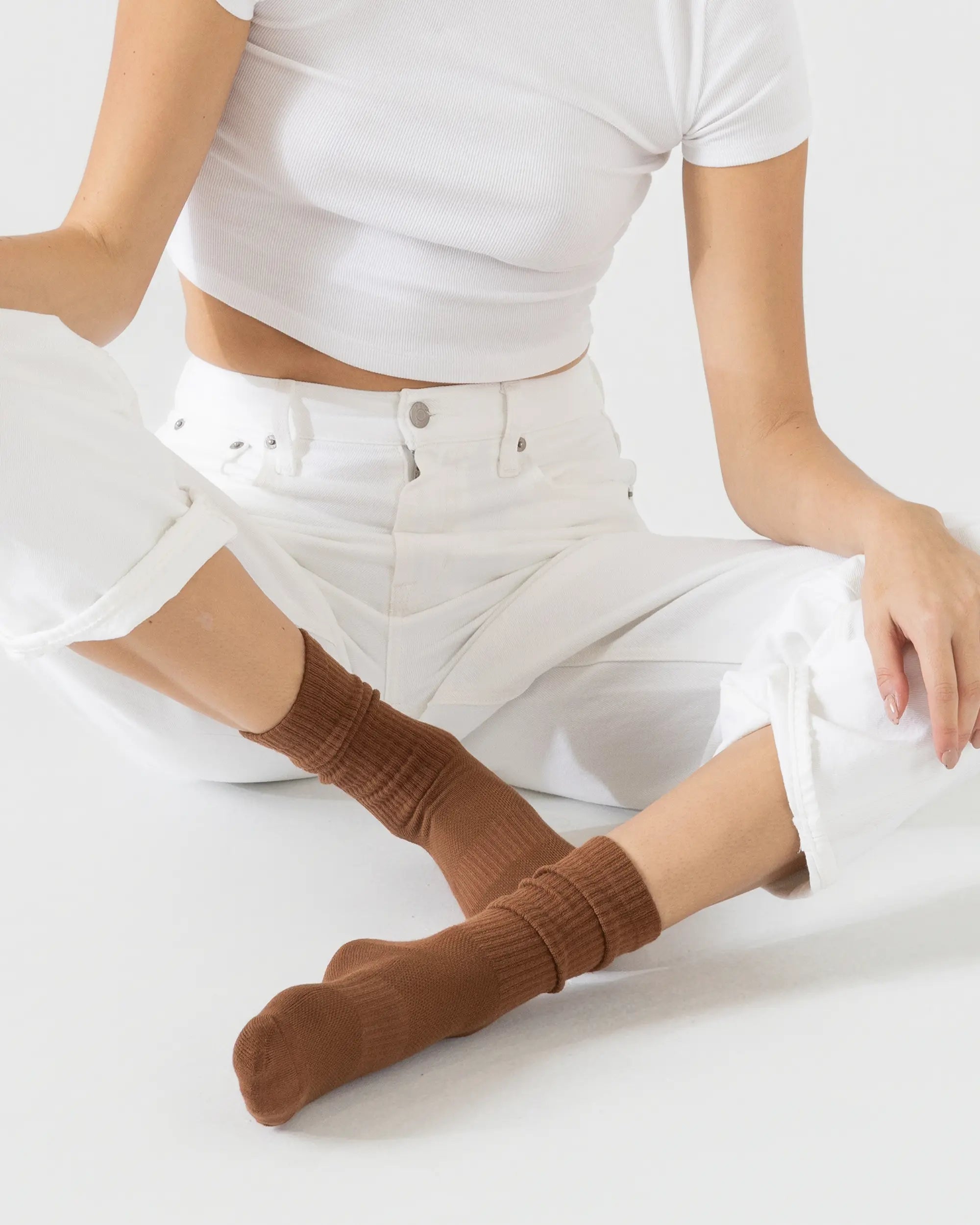 Person wearing brown sporty socks on a white background